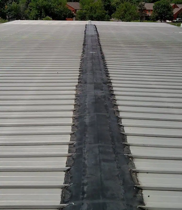 Black membrane strip running down a metal ridge