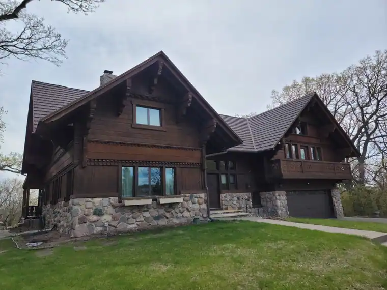 Fieldstone-based chalet home with a steep new roof